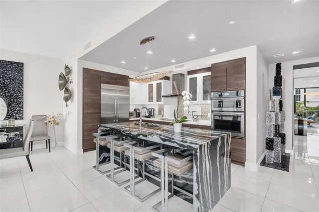 a kitchen with stainless steel appliances granite countertop a lot of cabinets and couches