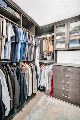 a view of walk in closet with clothes and shoes