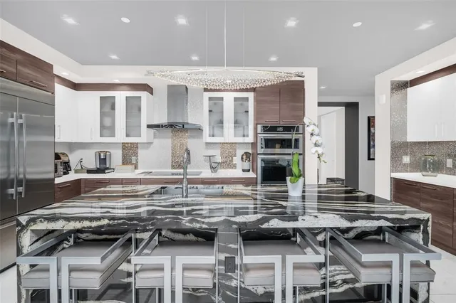 a kitchen with stainless steel appliances granite countertop a sink and a refrigerator