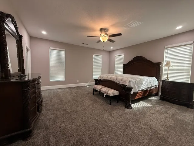a spacious bedroom with a bed and a chandelier