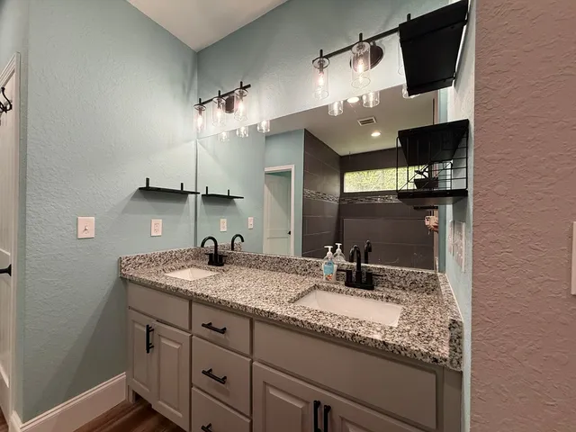 a bathroom with a granite countertop sink a large mirror and vanity