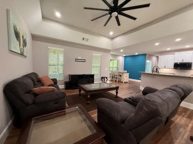 a living room with furniture kitchen view and a window