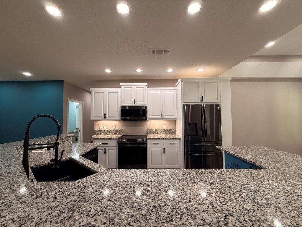 415 Autumn Ridge Drive Mineral Bluff, GA 30559 - Photo 6 of 21 a kitchen with kitchen island granite countertop a sink and stainless steel appliances