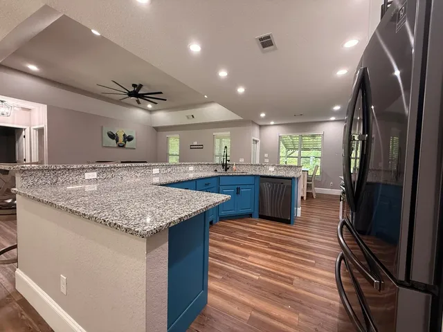a kitchen with stainless steel appliances granite countertop a sink stove and refrigerator