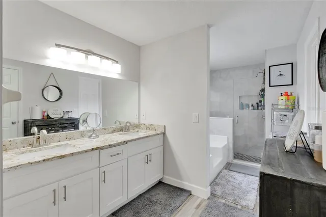 a en suite bathroom with a granite countertop sink and a mirror