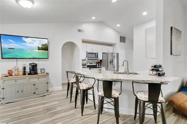 a kitchen with stainless steel appliances kitchen island granite countertop a table and chairs in it
