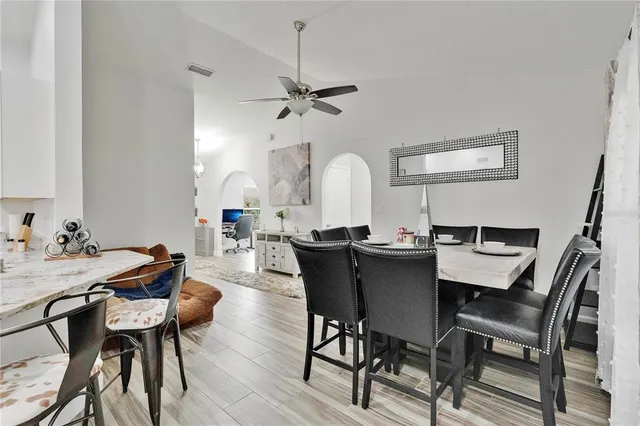 a view of a dining room with furniture and a chandelier fan