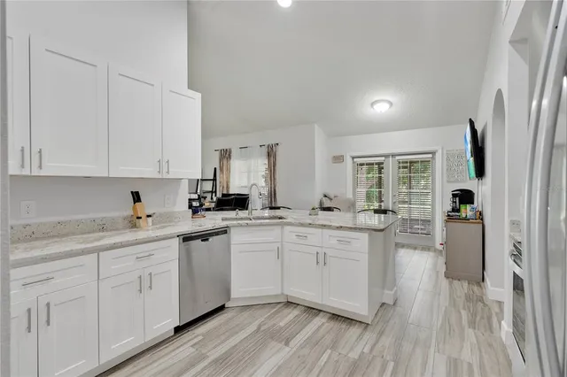 a kitchen with white cabinets sink and white stainless steel appliances
