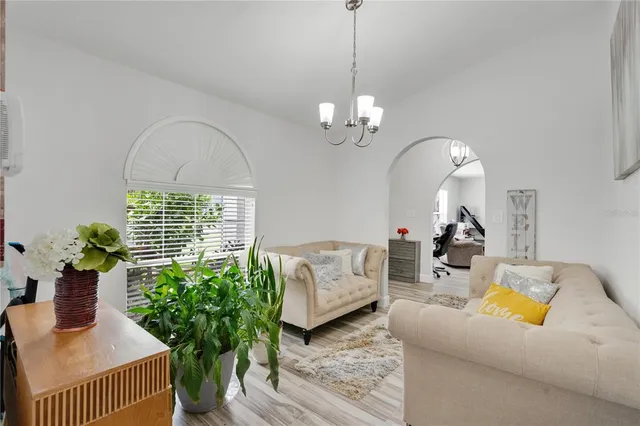 a living room with furniture chandelier and a window