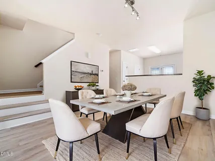 a view of a dining room and livingroom with furniture wooden floor and a rug