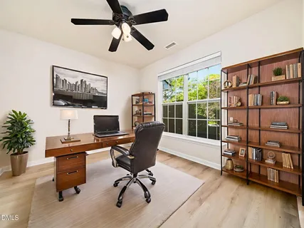 a view of a workspace with furniture and a window