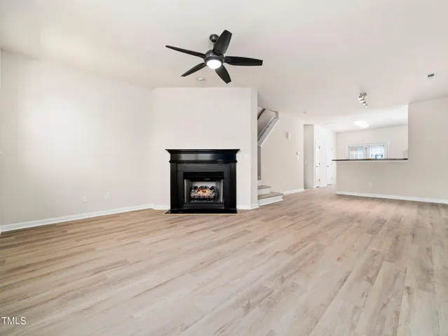 a view of empty room with wooden floor and fireplace