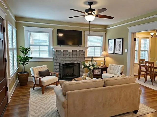 a living room with furniture a flat screen tv and a fireplace