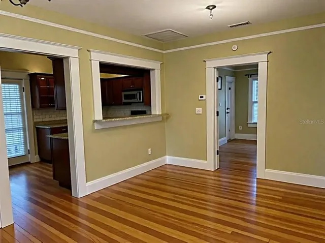 a view of a hallway with wooden floor and staircase