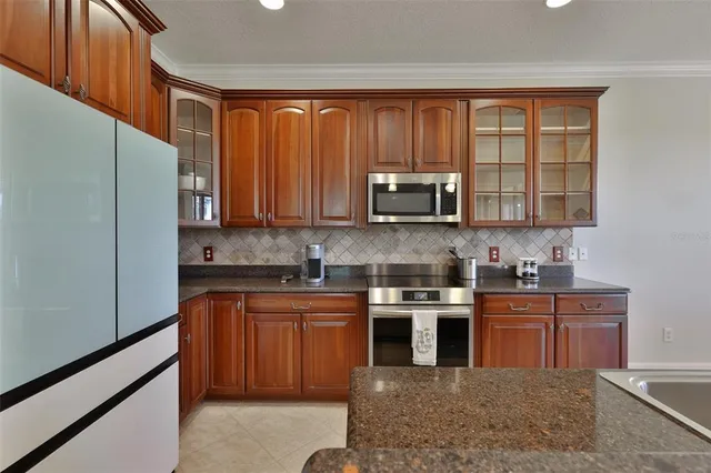 a kitchen with stainless steel appliances granite countertop wooden cabinets a sink and a stove