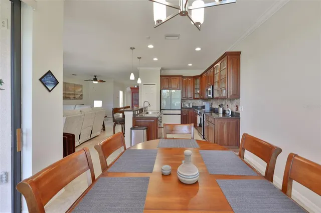 a living room with stainless steel appliances furniture windows and a view of kitchen