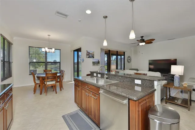 a kitchen with a counter space a sink appliances and living room view