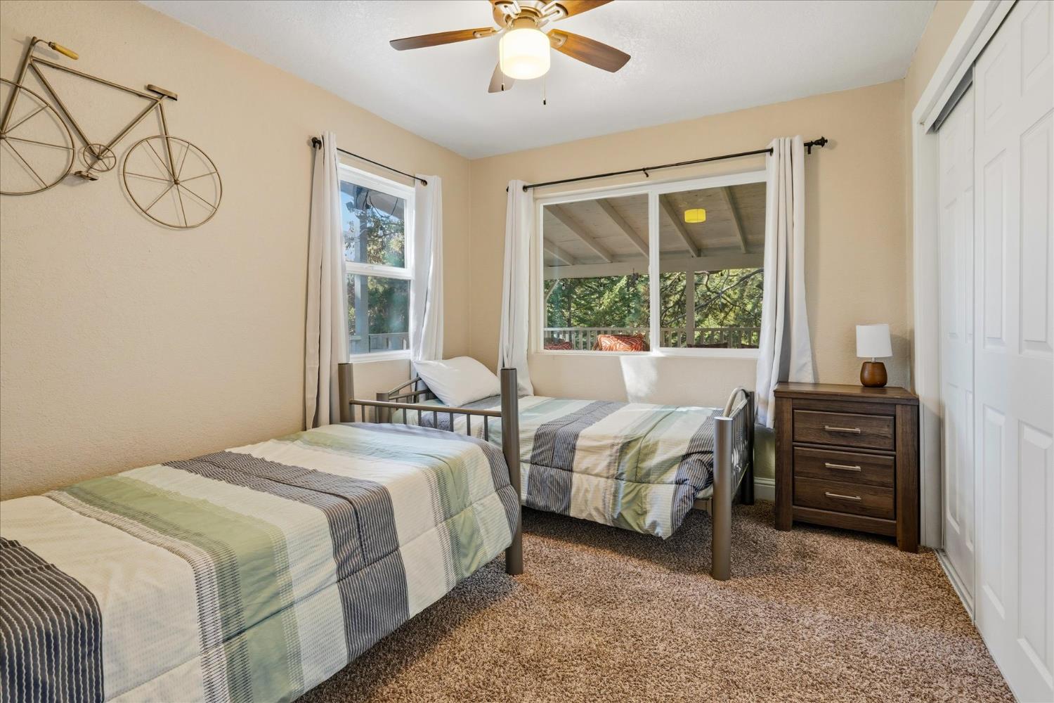 50740 Chu Ranch Road Oakhurst, CA 93644 - Photo 22 of 37 a bedroom with a bed and a chandelier