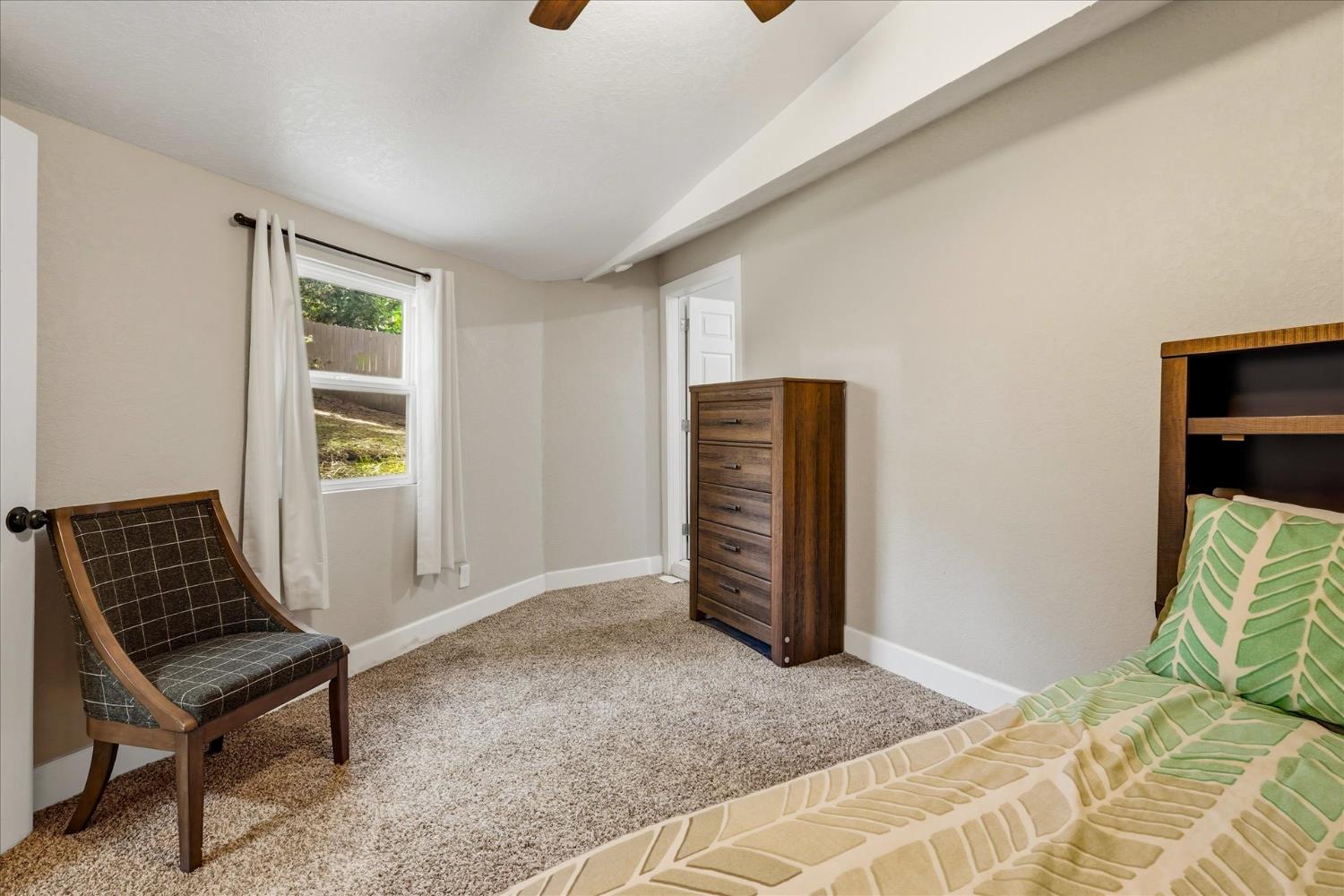 50740 Chu Ranch Road Oakhurst, CA 93644 - Photo 28 of 37 a bedroom with a bed and a chair