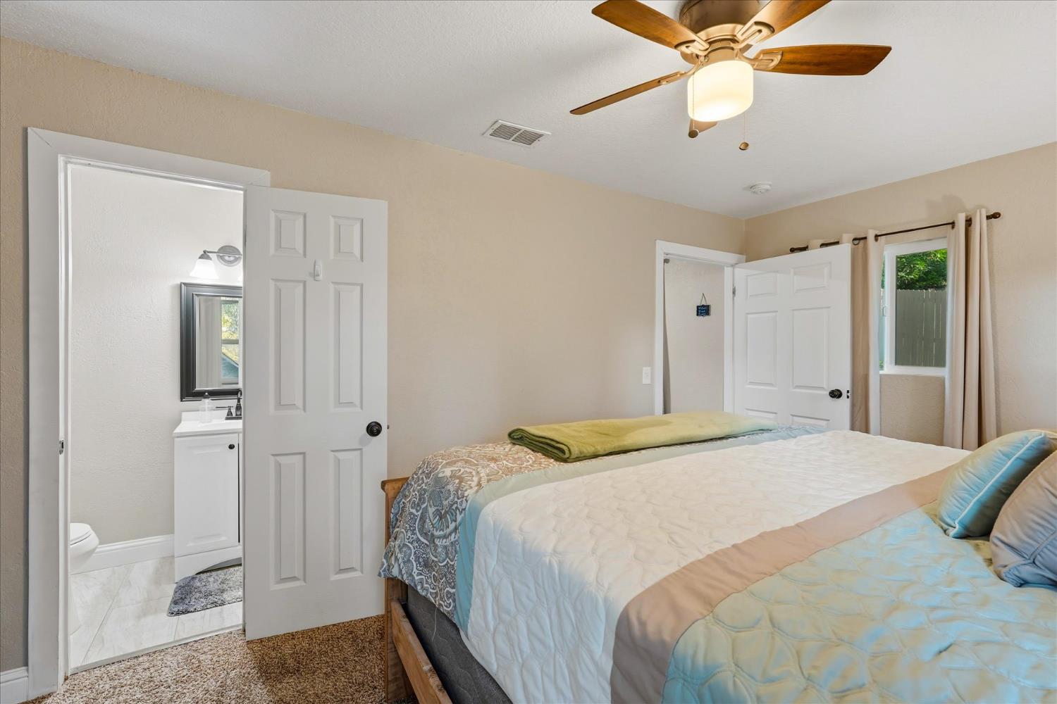 50740 Chu Ranch Road Oakhurst, CA 93644 - Photo 31 of 37 a bedroom with a bed and a chandelier