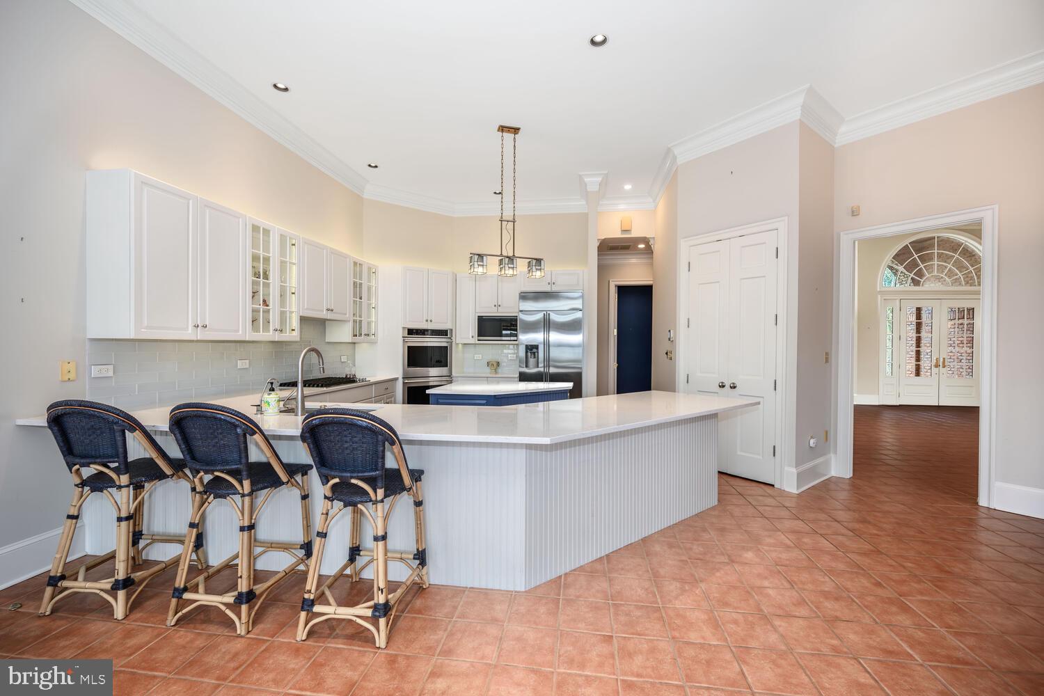 23961 Lynnewood Drive St. Michaels, MD 21663 - Photo 40 of 81 a kitchen with a table chairs refrigerator and cabinets