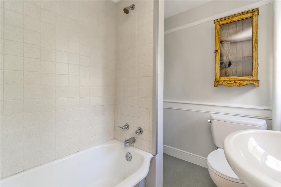 1325 Granger Road Northampton, PA 18067 - Photo 36 of 61 Tiled bath enclosure with a shower head and a classic gold-framed mirror above the toilet.