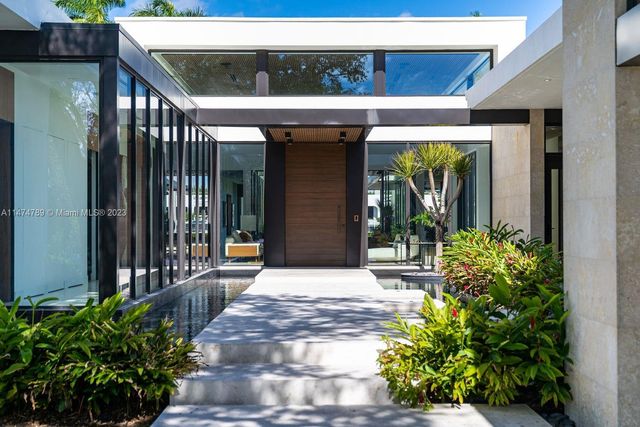 a dining room with a table chairs and a kitchen view