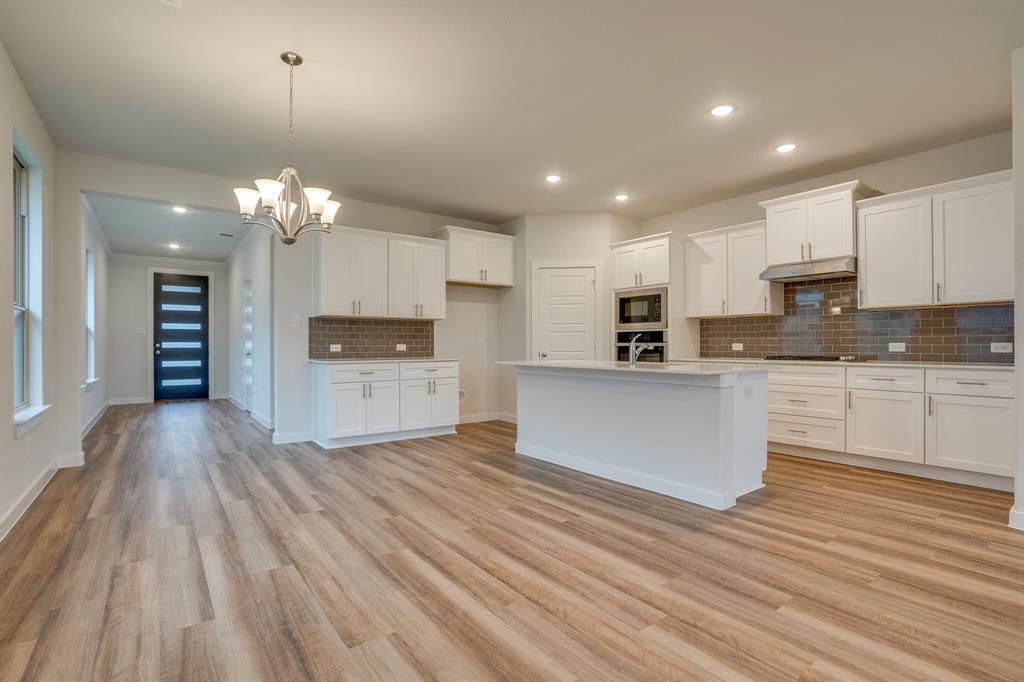a large kitchen with kitchen island a sink stainless steel appliances and cabinets