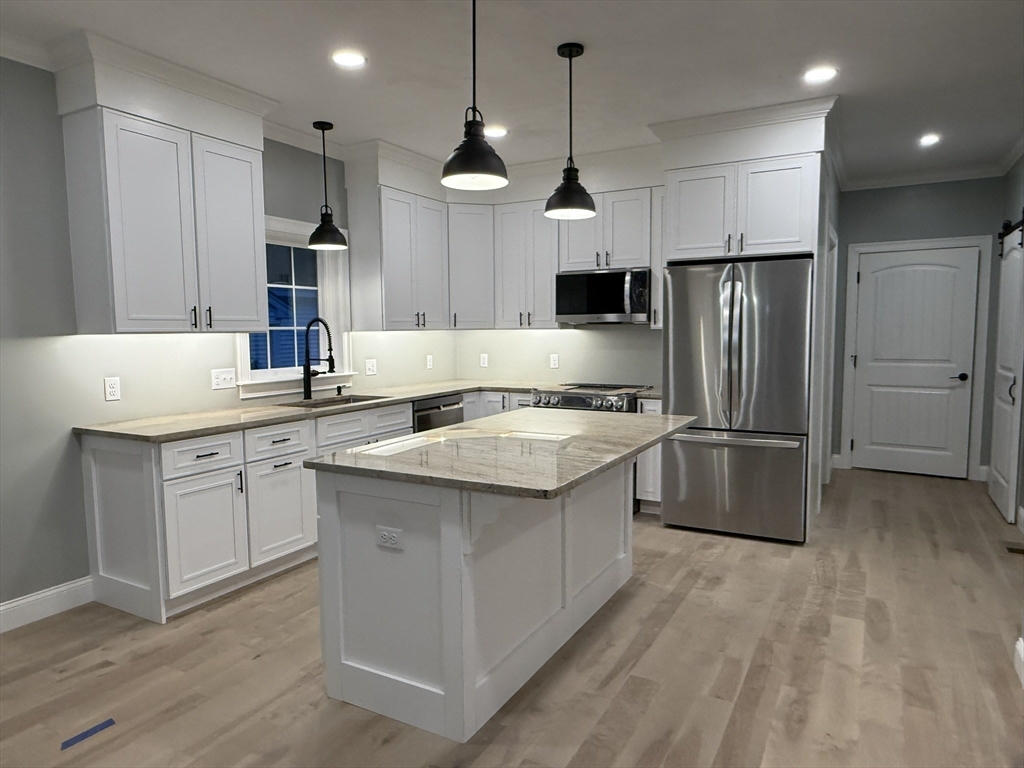 22 Cooper Road Webster, MA 01570 - Photo 7 of 42 a kitchen with kitchen island a sink stainless steel appliances and refrigerator