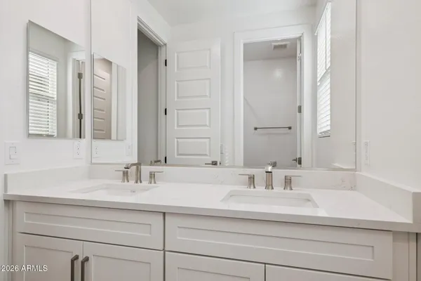 a bathroom with double sink and a mirror