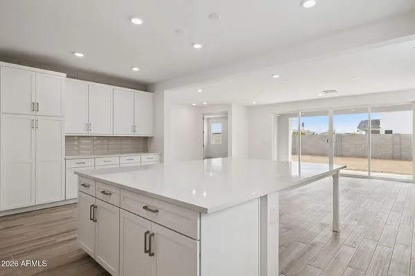 a view of a kitchen with kitchen island a sink appliances and cabinets