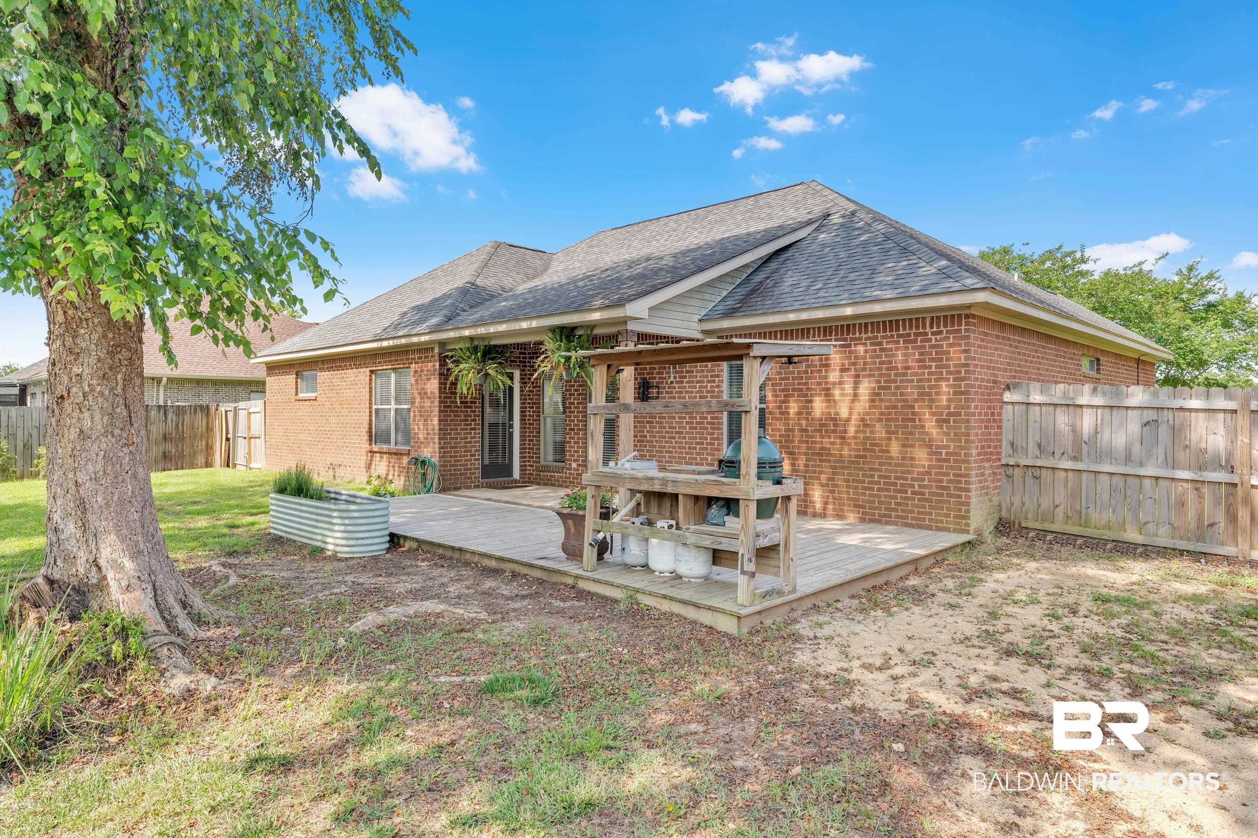 9508 Collier Loop Daphne, AL 36526 - Photo 6 of 29 Rear view of house with brick siding, a deck, and a fenced backyard