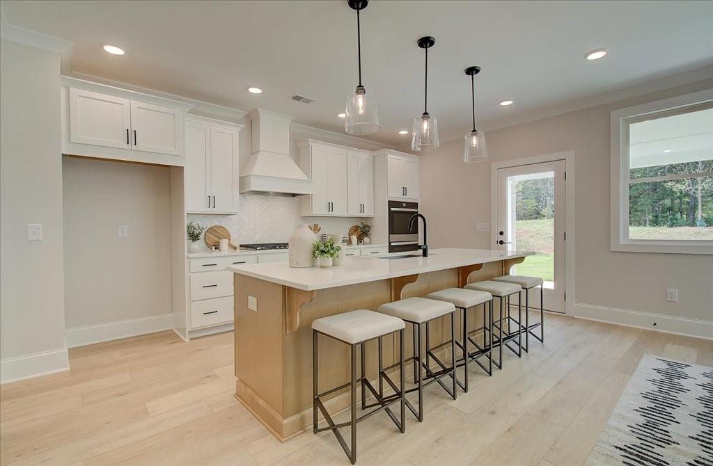 302 Evie Lane Canton, GA 30115 - Photo 18 of 45 a kitchen with kitchen island granite countertop a table chairs sink and cabinets