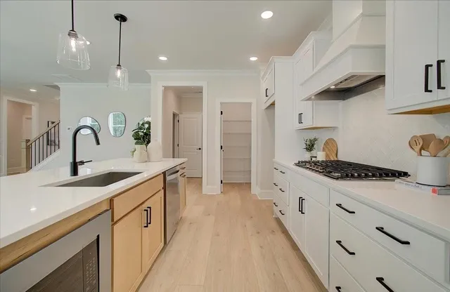 a kitchen with stainless steel appliances a sink stove and cabinets