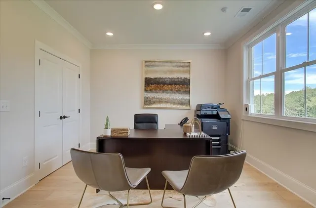 a view of a workspace with furniture and a window