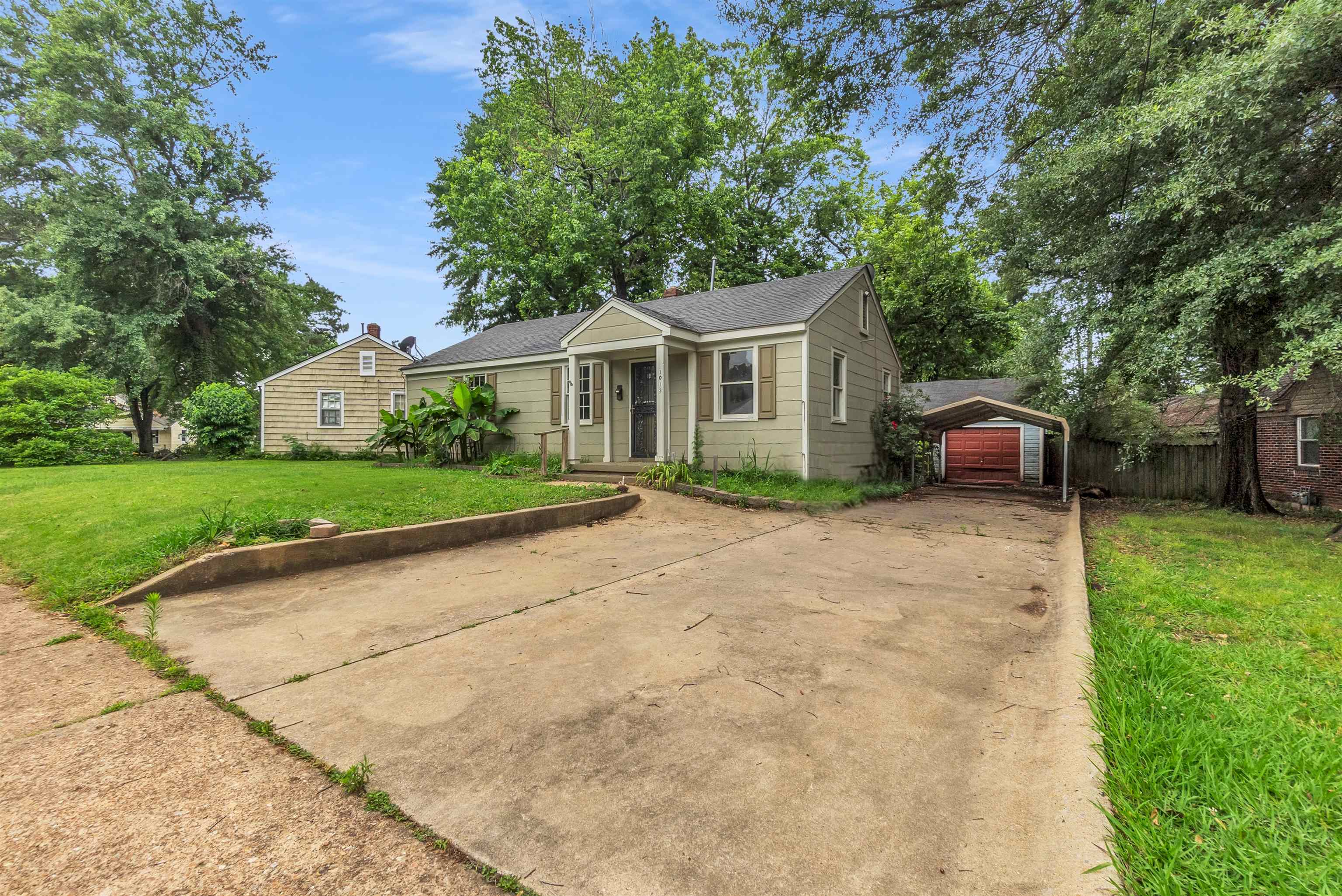 1013 Waring Road Memphis, TN 38122 - Photo 2 of 11 a front view of a house with a garden and trees