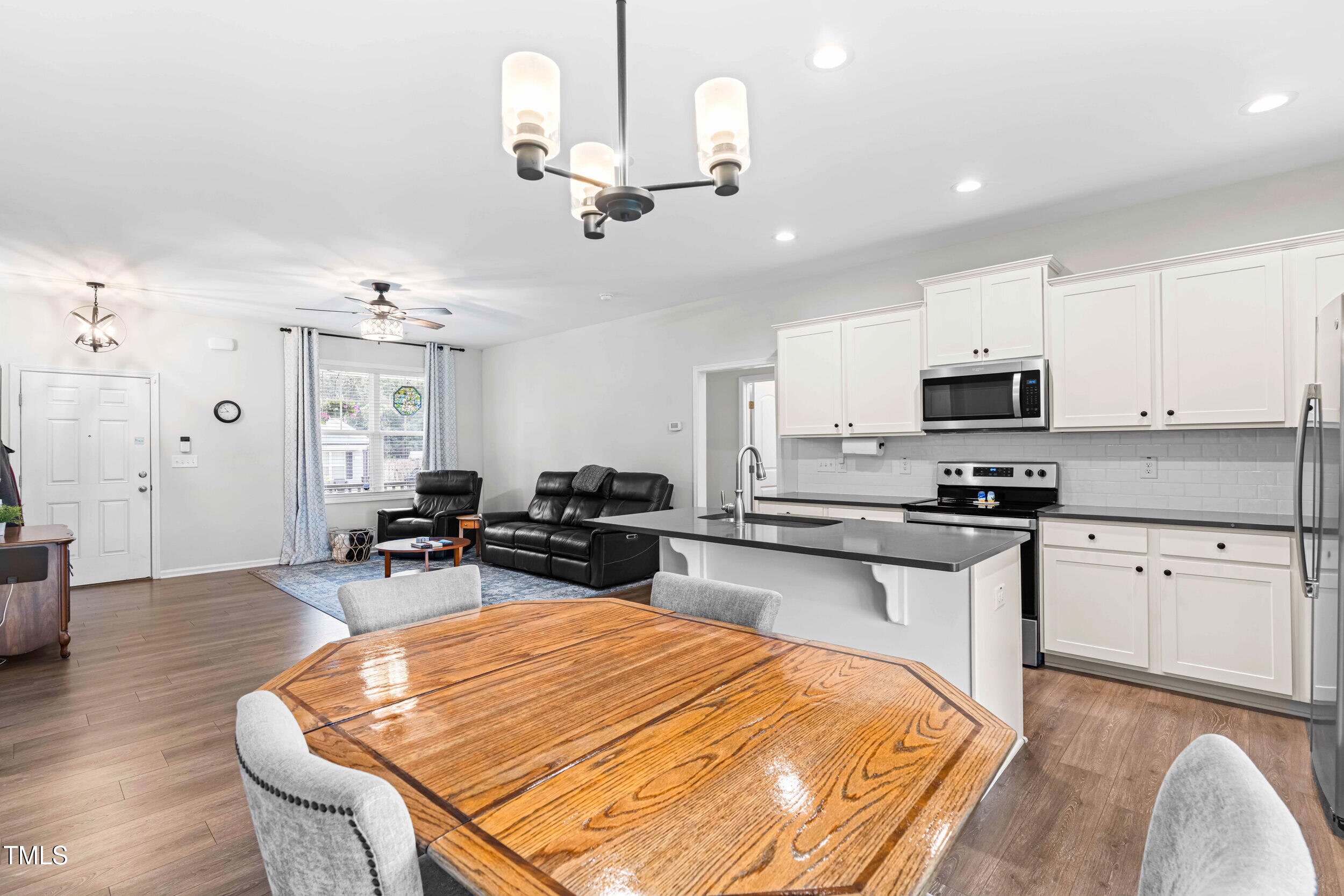 173 Longbow Drive Middlesex, NC 27557 - Photo 15 of 32 a kitchen with stainless steel appliances granite countertop a stove top oven a sink a dining table and chairs with wooden floor