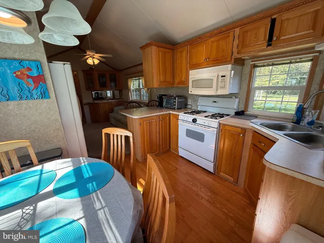 a kitchen with stainless steel appliances granite countertop a sink a stove a refrigerator a microwave oven with a dining table and chairs