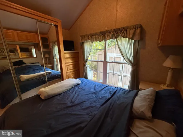 a bedroom with a bed next to a window