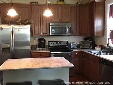 a kitchen with stainless steel appliances granite countertop a sink a stove and a refrigerator