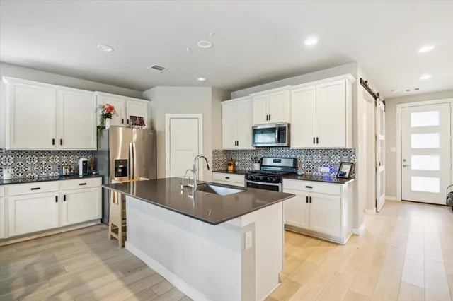 a spacious bathroom with a double vanity sink a large mirror and shower