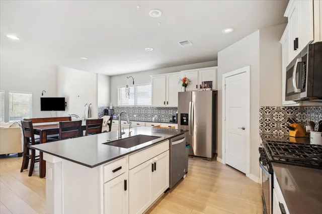a kitchen with white cabinets and stainless steel appliances