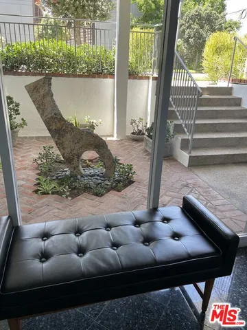 a view of a house with a yard and potted plants
