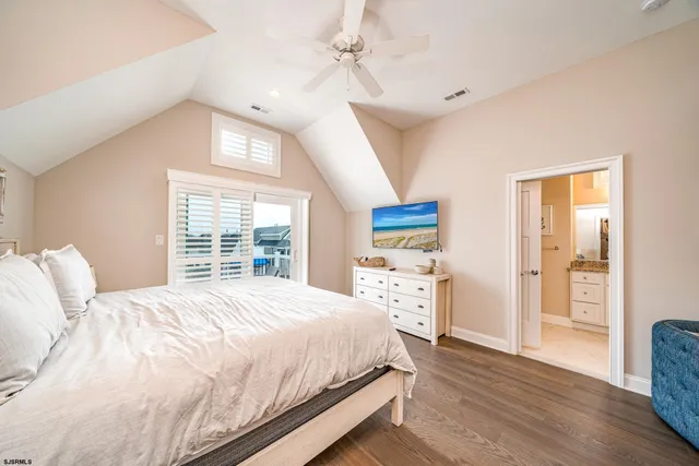 a bedroom with a large bed a chandelier and a window
