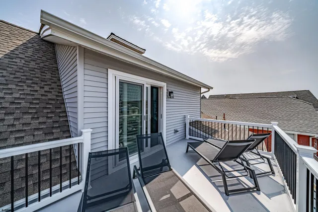 a balcony with wooden floor outdoor seating and barbeque oven