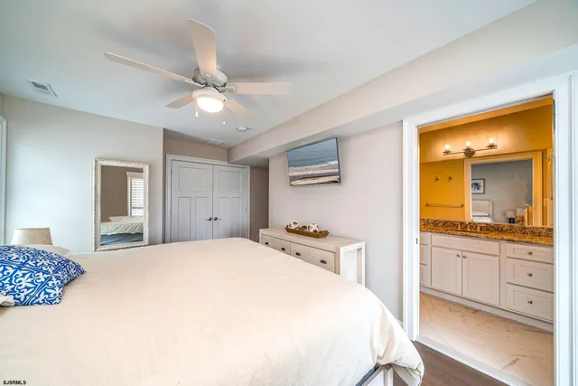 a spacious bedroom with a large bed and a chandelier