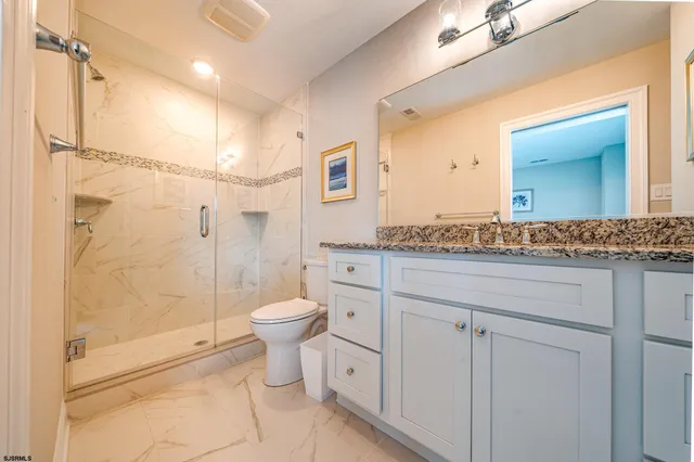 a bathroom with a granite countertop sink toilet and shower