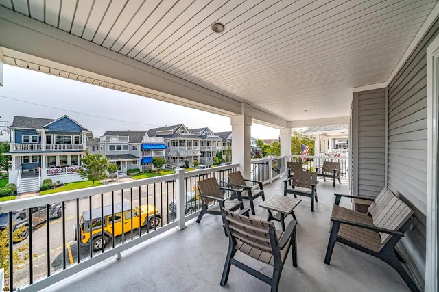 a view of a chairs and table in patio with a balcony