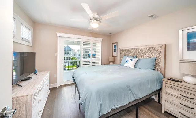 a bed sitting in a bedroom next to a window with a flat screen tv