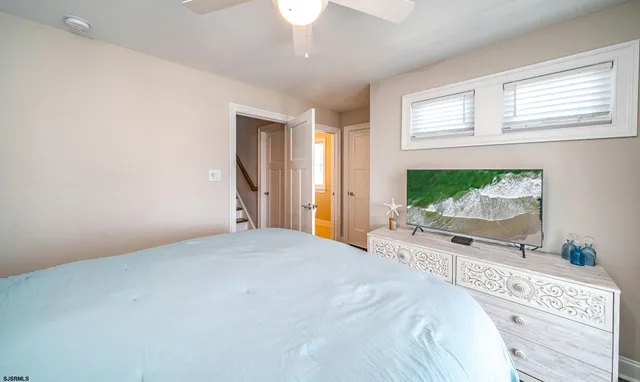 a spacious bedroom with a large bed and a chandelier